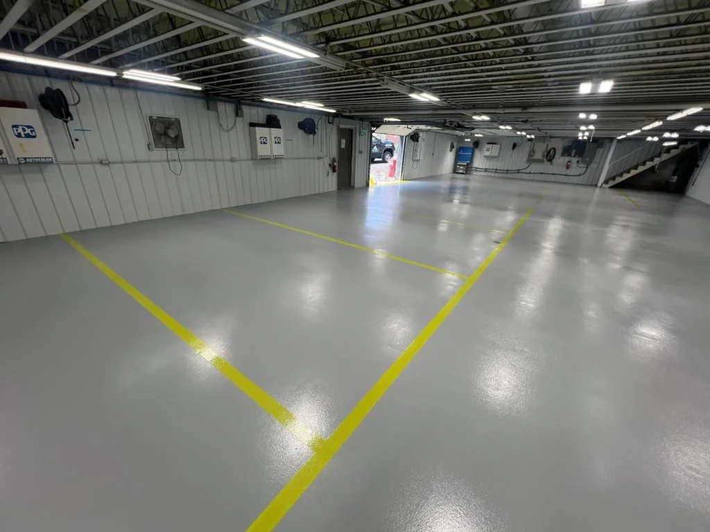 Grey industrial floor and yellow safety lines in Chapman Auto Body shop
