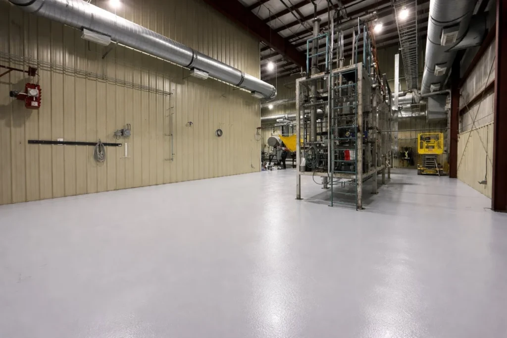 Light-coloured coated warehouse floor around equipment at Sustane Technologies
